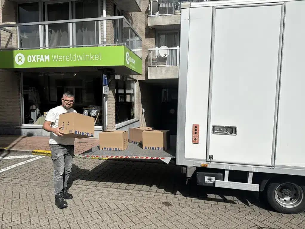 Medewerker van Inboedelopruimen.com brengt dozen met herbruikbare spullen naar Oxfam-Wereldwinkel in Knokke-Heist