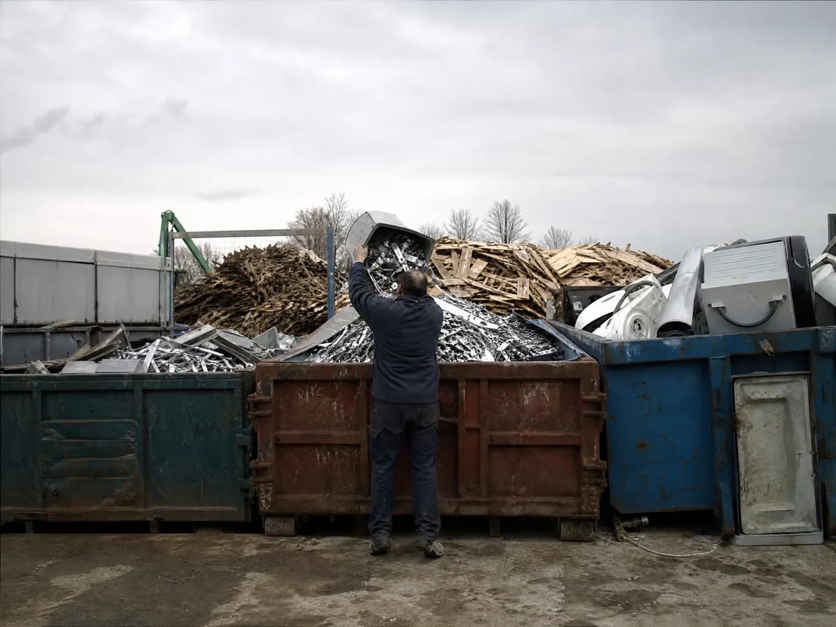 Gesorteerde stromen hout, metaal en elektro na een opruiming in aparte containers