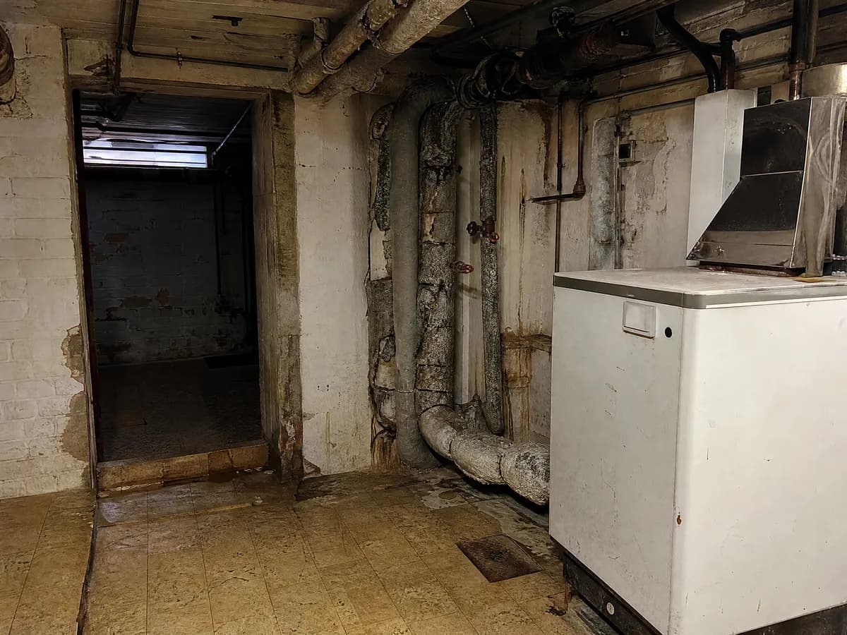 Oude vinyltegels en leidingisolatie in een kelder, typische plaatsen voor asbest