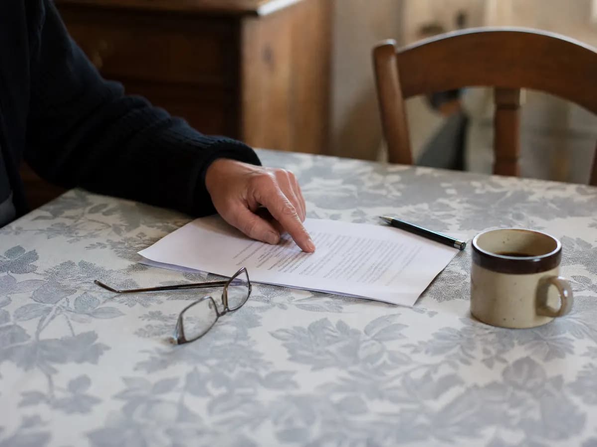 Offerte van een opruimfirma nalezen aan de keukentafel voor u tekent