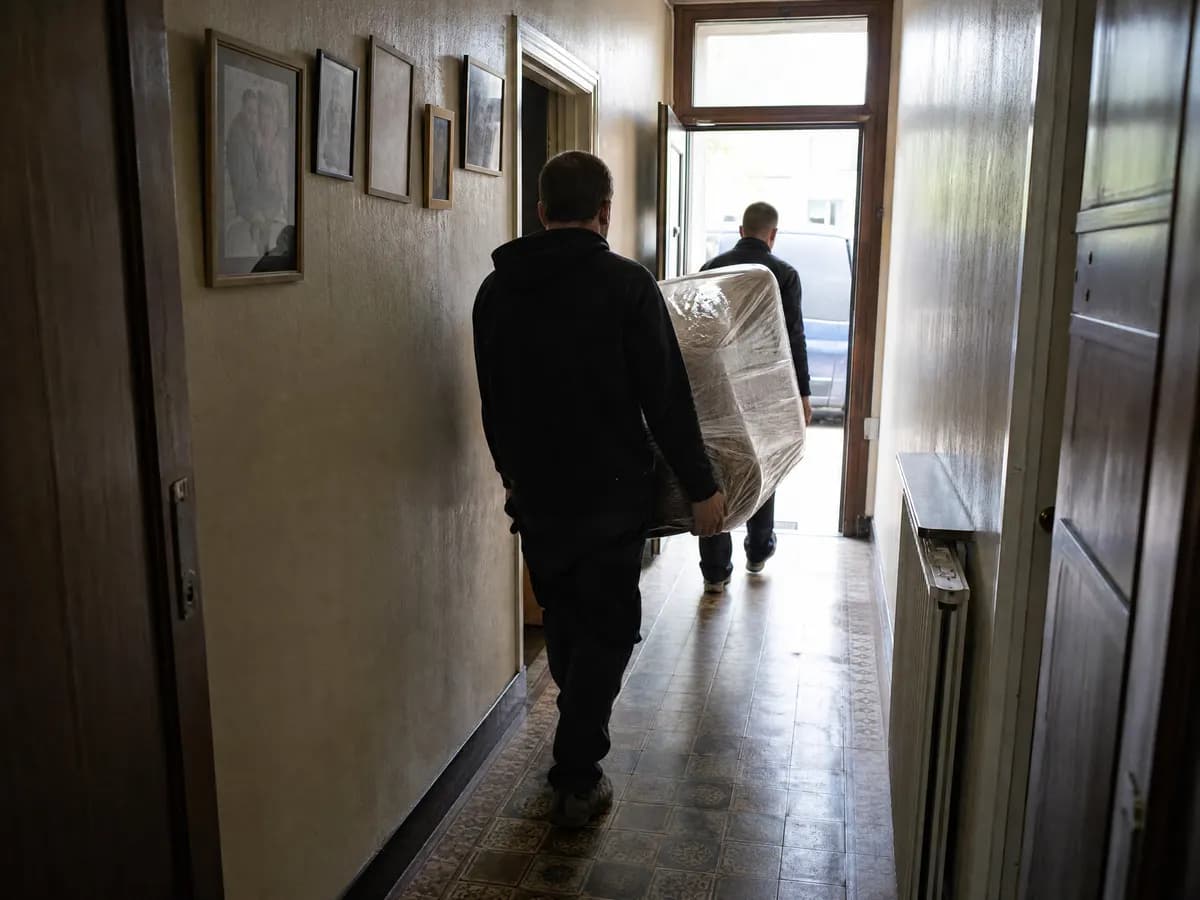 Opruimers dragen voorzichtig meubels uit het ouderlijk huis na de verdeling